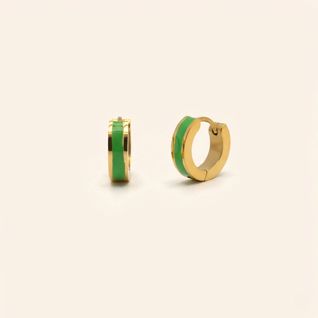 Gold hoop earrings with green accents on a beige background