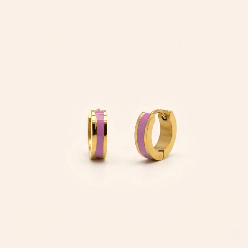 Gold hoop earrings with pink interior on a beige background