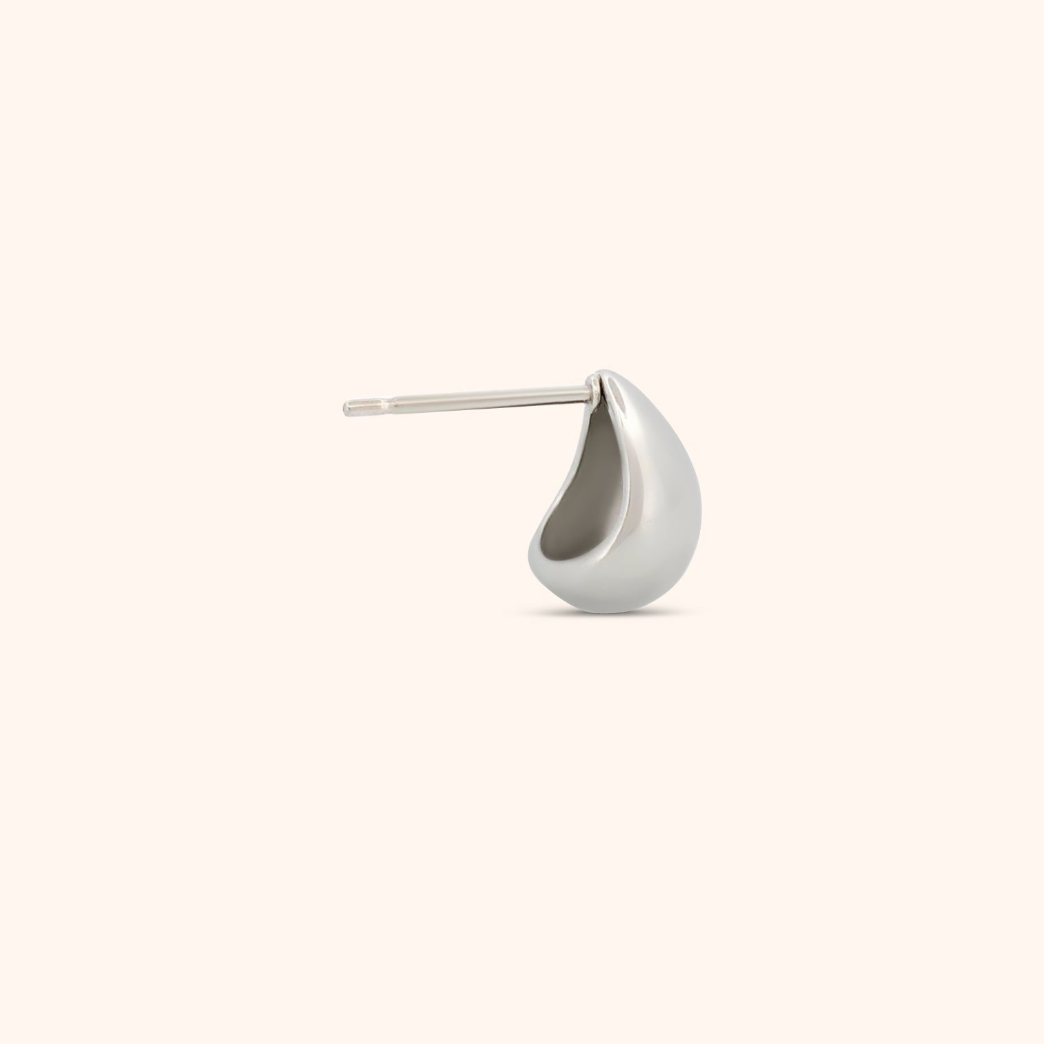 Close-up of a single teardrop earring, showcasing its smooth, reflective surface and lightweight design.