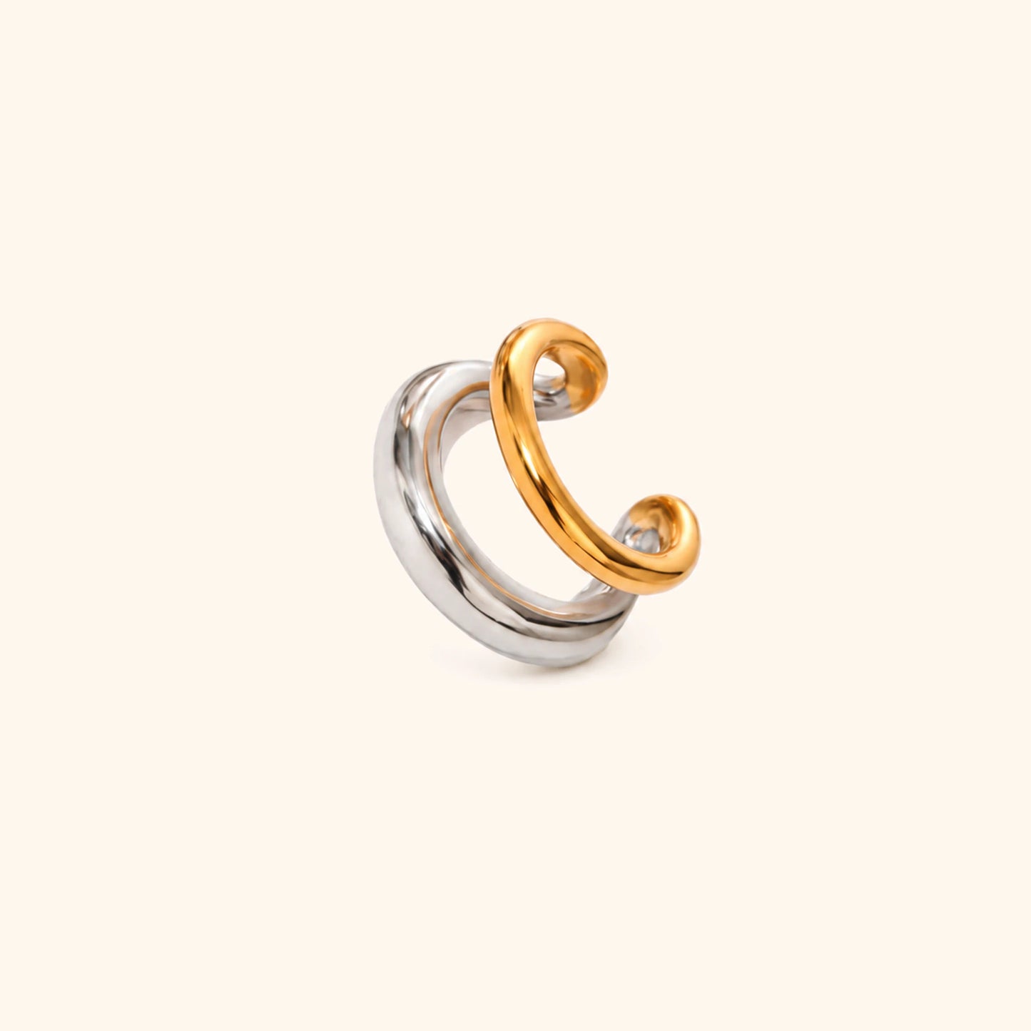 Gold and silver ear cuff on a white background